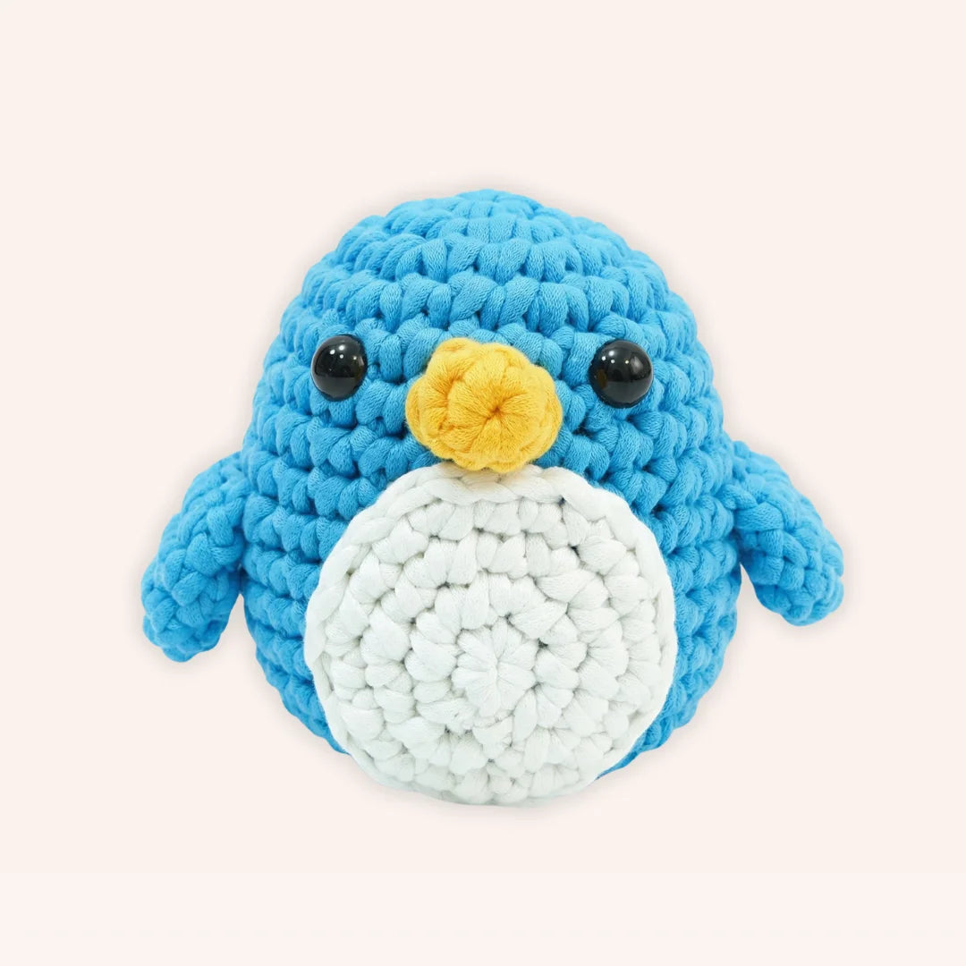 The Little Penguin mini crochet amigurumi with blue body, white belly, yellow beak and black safety eyes