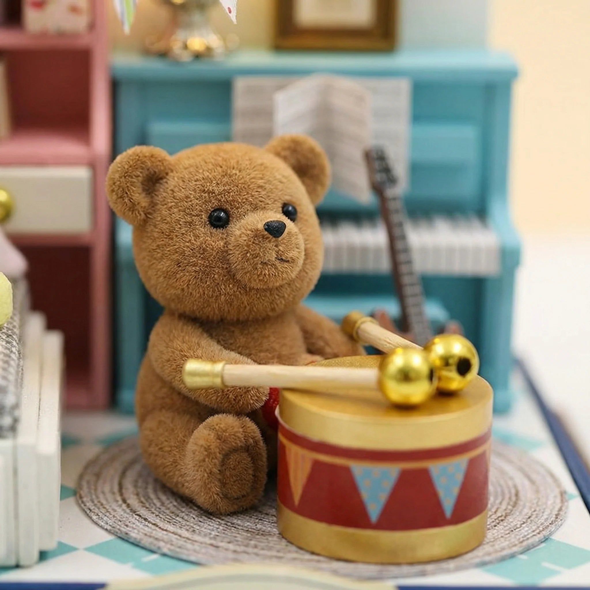 The Little Maestro mini crochet bear with golden drum and drumstick in dollhouse music room setting