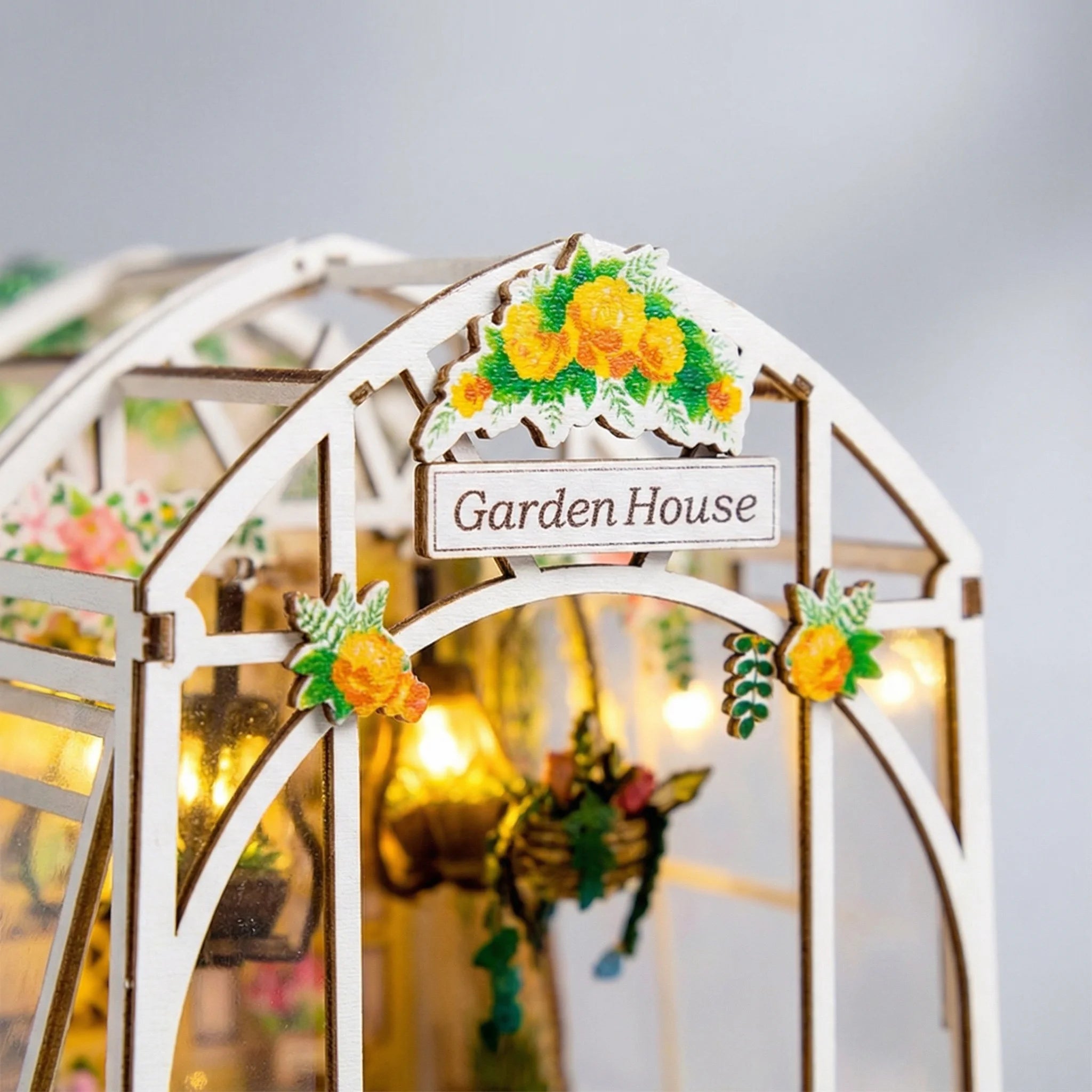 Garden House miniature DIY kit with illuminated greenhouse showing yellow flowers and decorative arch entrance