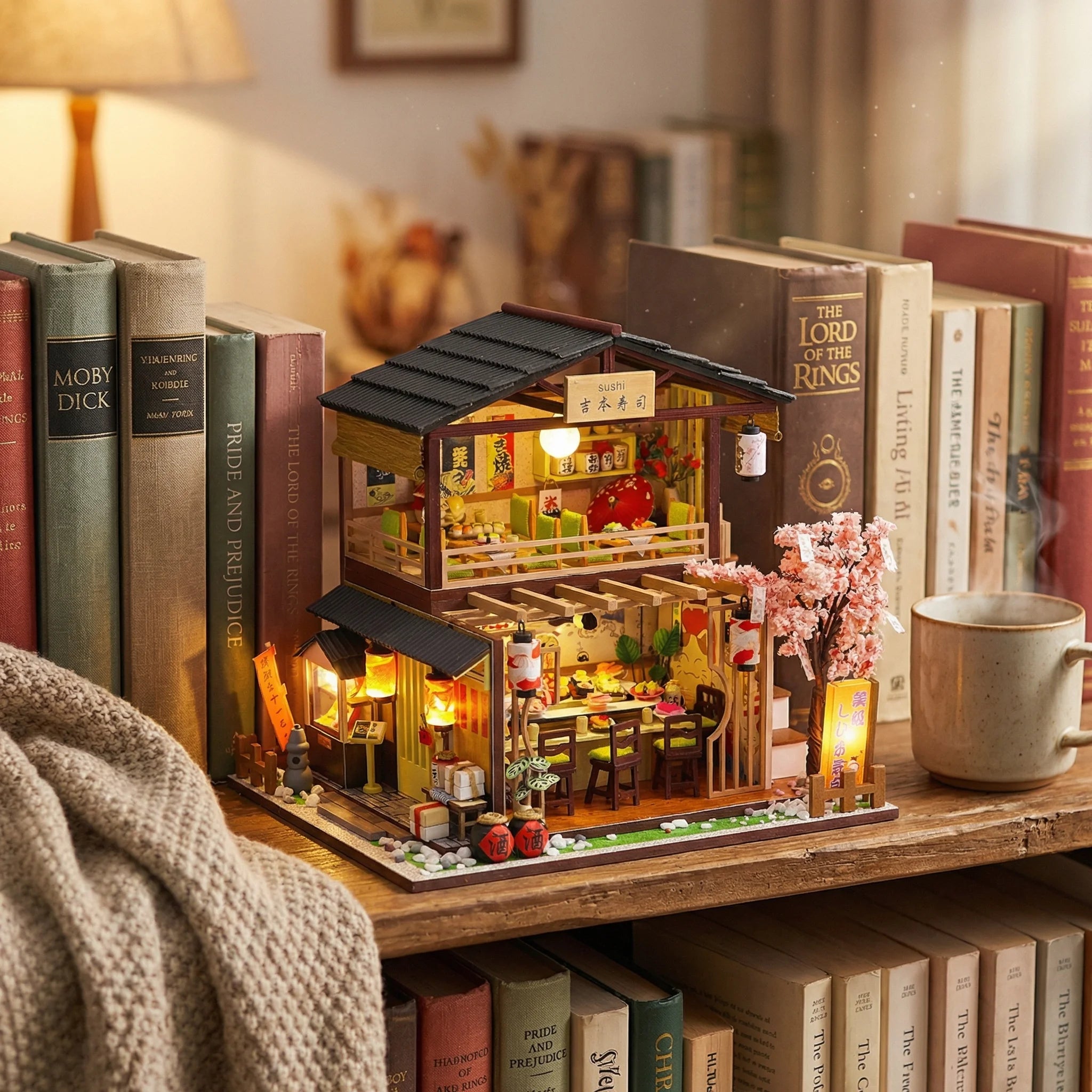 The Sakura Sushi Bar miniature kit displayed on bookshelf with warm lighting, cherry blossom tree, and Japanese restaurant...