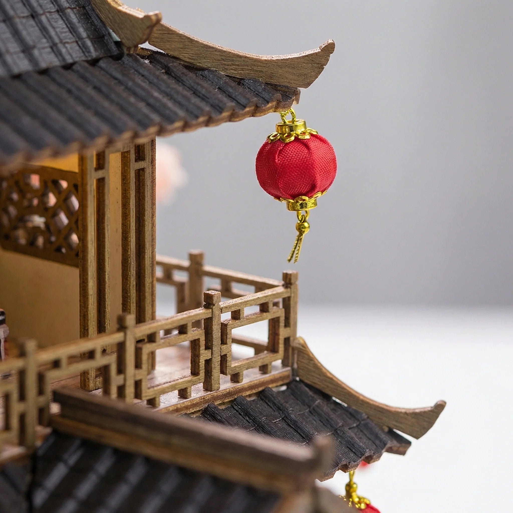 The Lotus Pavilion miniature kit detail showing traditional curved roof with red fabric lantern and wooden railings