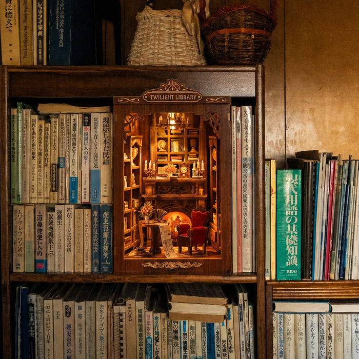 The Twilight Library book nook lit up between books on a wooden bookshelf