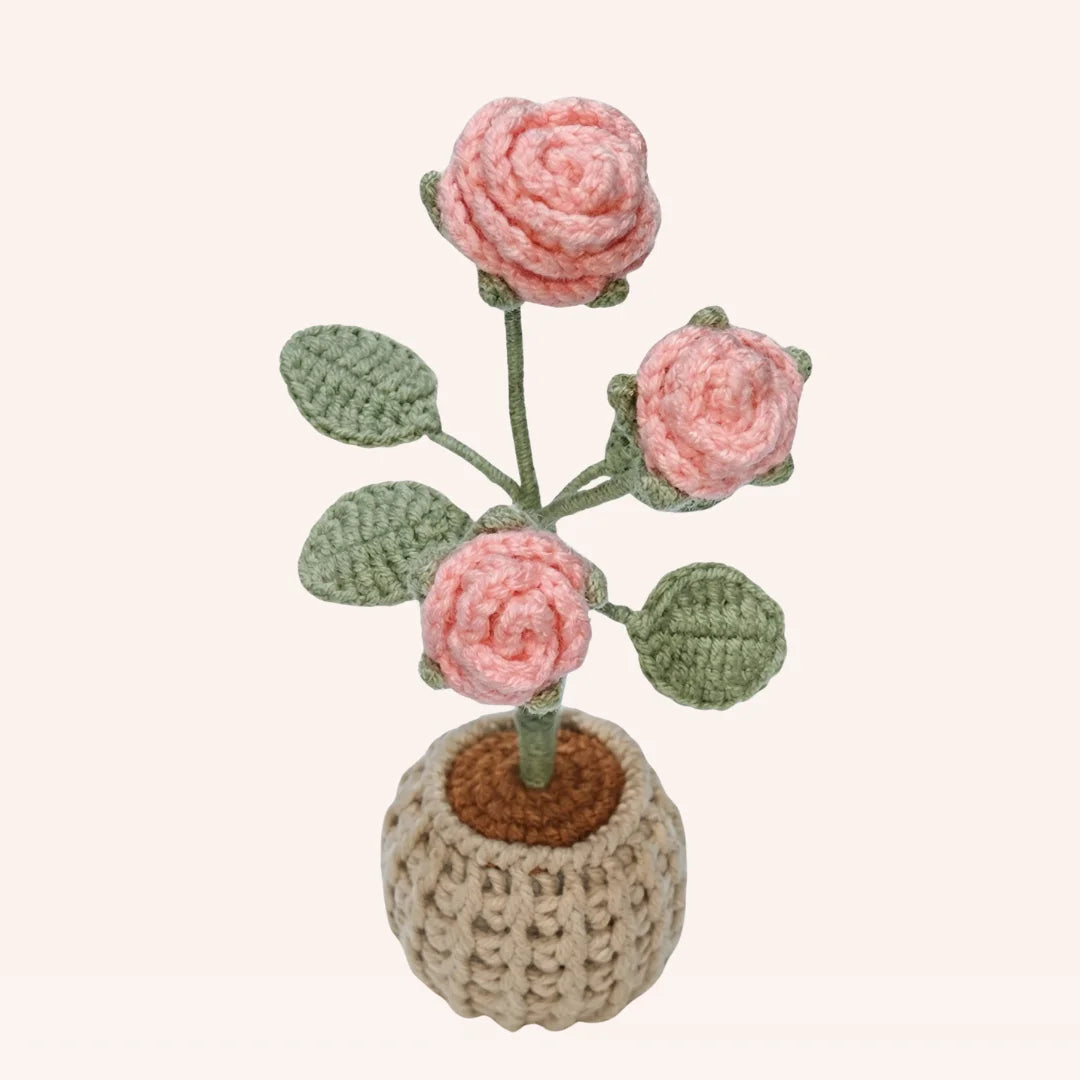 Handmade crochet rose garden with three pink roses, green leaves and stems in beige pot amigurumi decoration