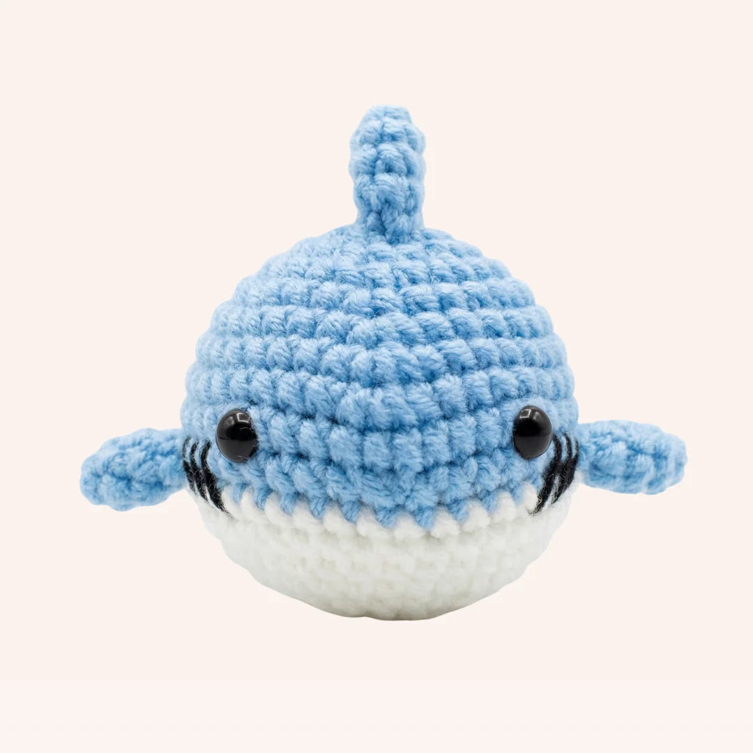 The Ocean Grin mini crochet shark amigurumi kit with light blue yarn, white belly, and adorable smile