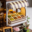 Treat counter detail: tilted bins of kibble and biscuits under the striped awning