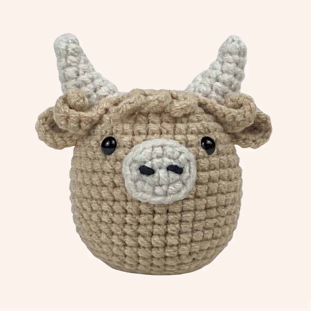 Hamish the Highland Cow crochet amigurumi kit showing beige crocheted cow head with white horns and snout