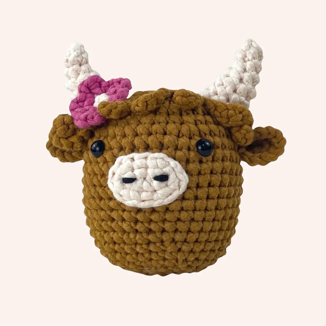 Rosie the Highland Cow mini crochet amigurumi kit with mustard yellow body, pink flower and white braided horns