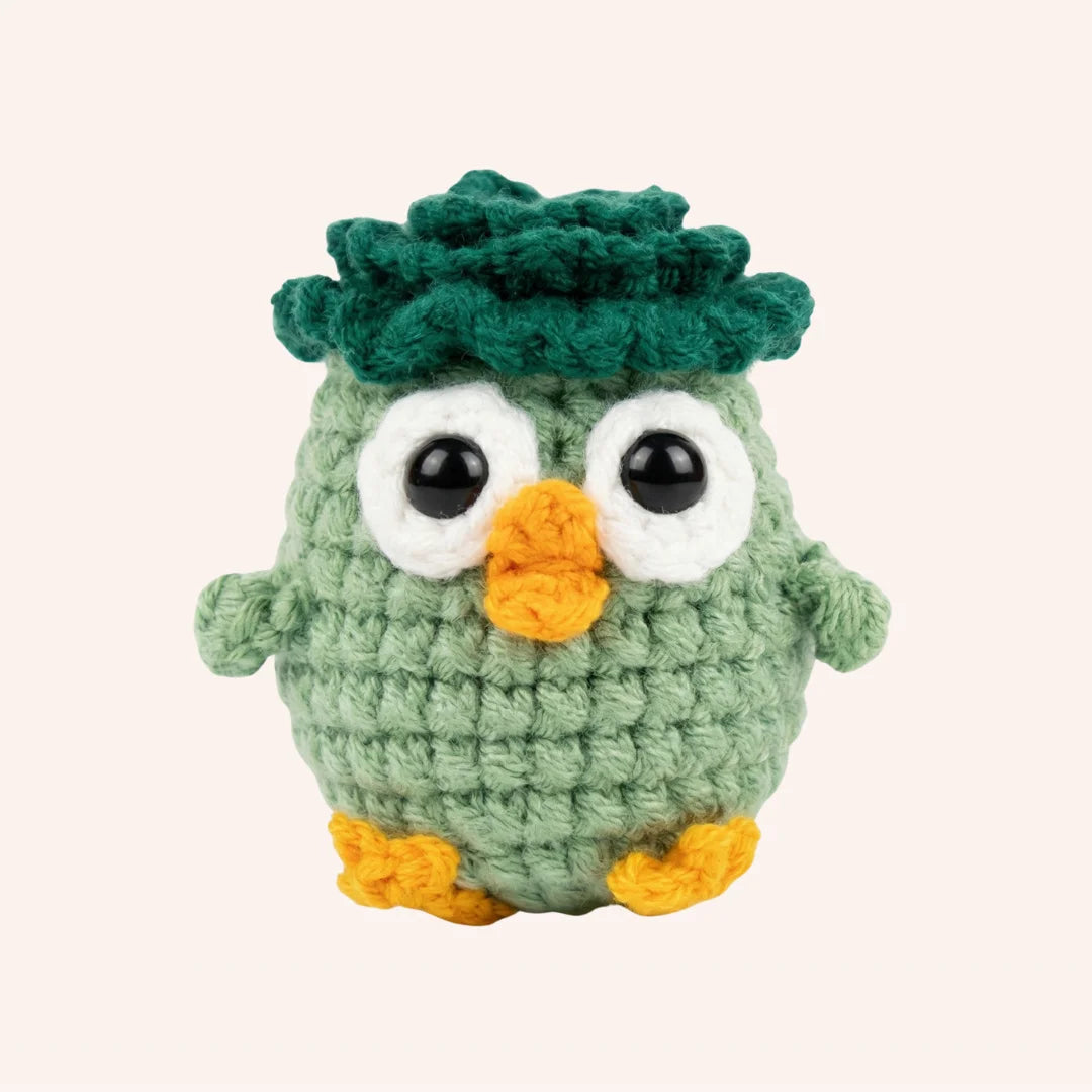 The Wise Oak mini crochet amigurumi owl with green body, dark green textured head and orange beak and feet