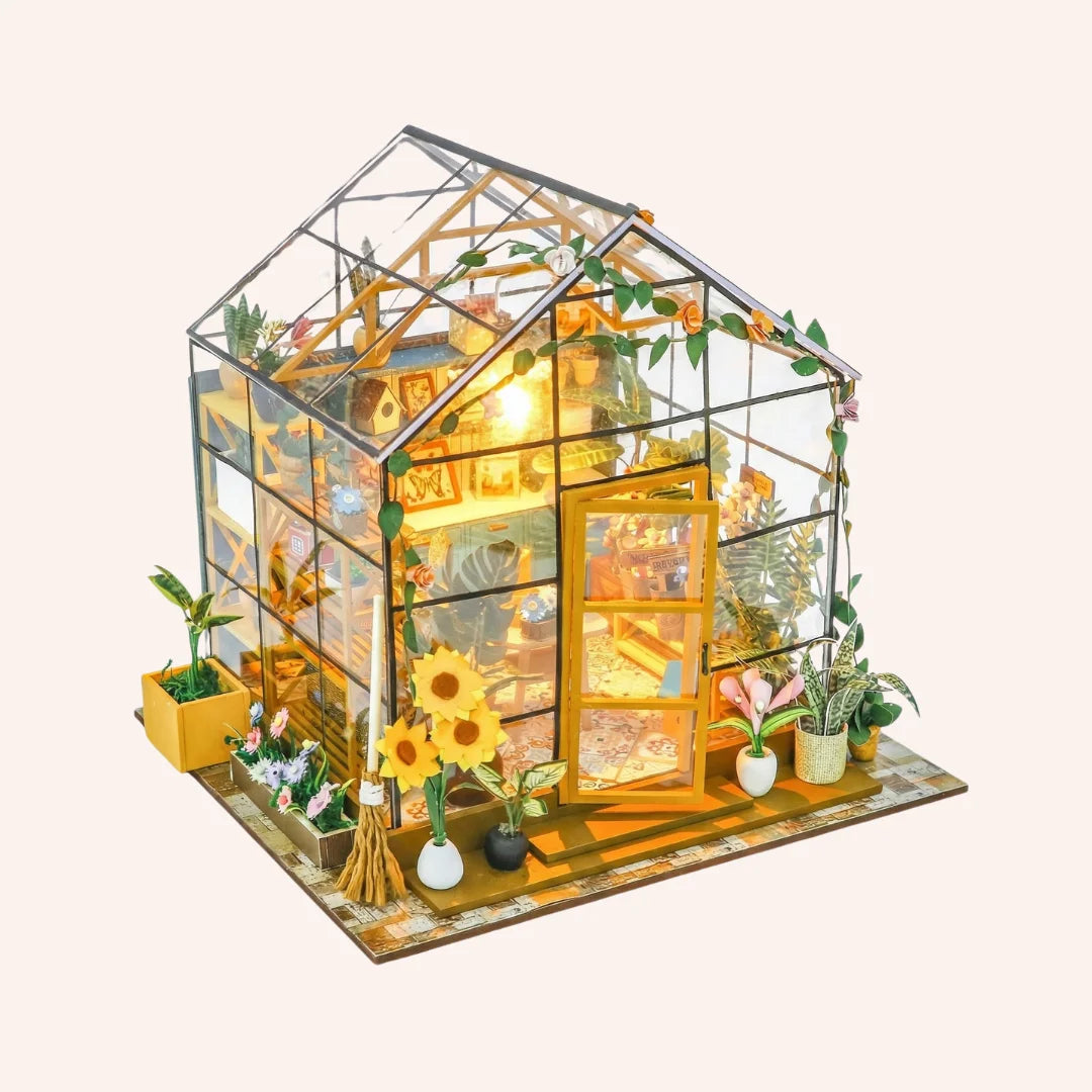 The Sunflower Glasshouse DIY miniature kit with glass greenhouse structure, yellow door, plants and warm LED lighting