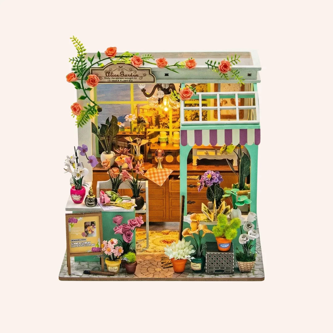 The Blossom Studio DIY miniature dollhouse kit with flower shop facade, plants, and warm lighting