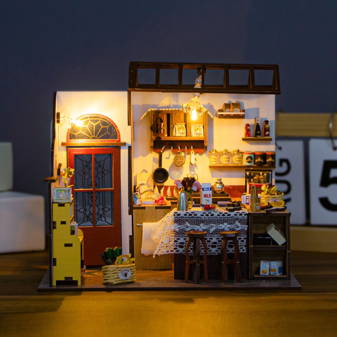 The Homely Kitchen DIY miniature dollhouse kit with LED lights showing detailed kitchen interior and red door