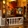 Close-up of the upper level of The Artist's Studio with round window, curtains and balcony