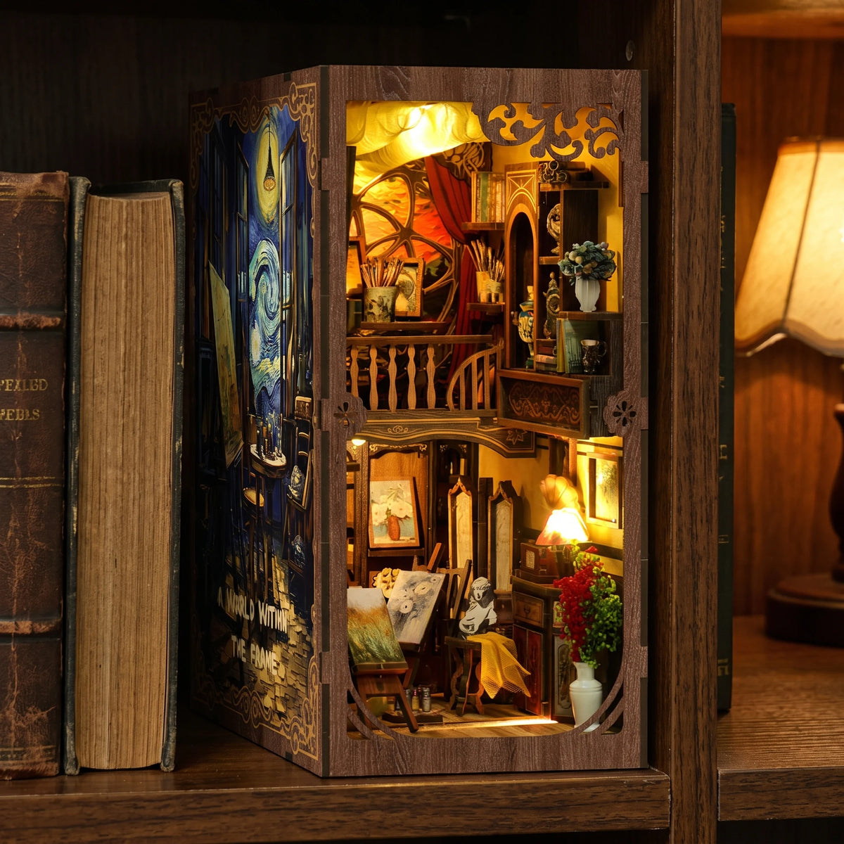 The Artist's Studio book nook slotted on a bookshelf between books at dusk
