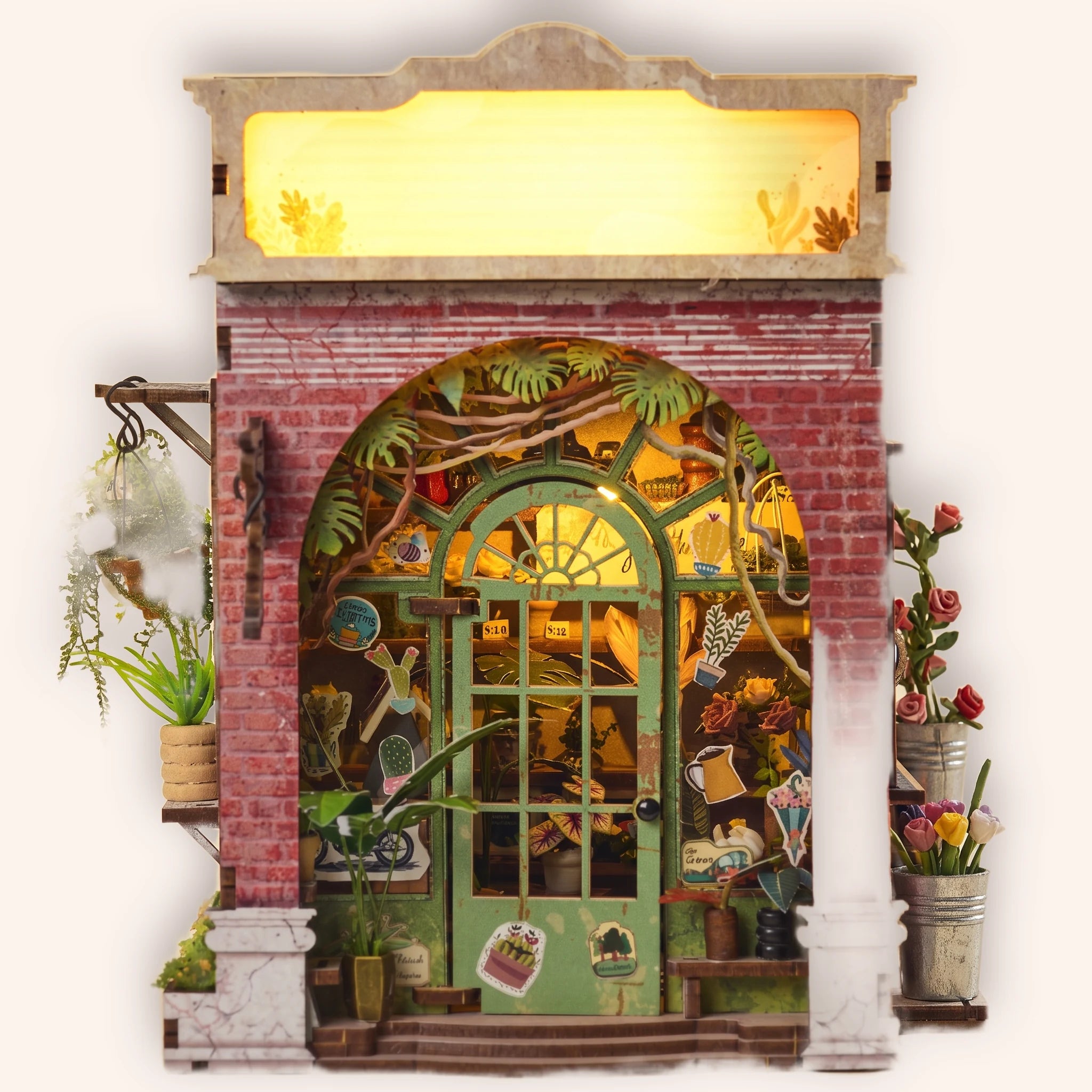 The Blossom House miniature red-brick florist book nook, lit, on a cream studio background