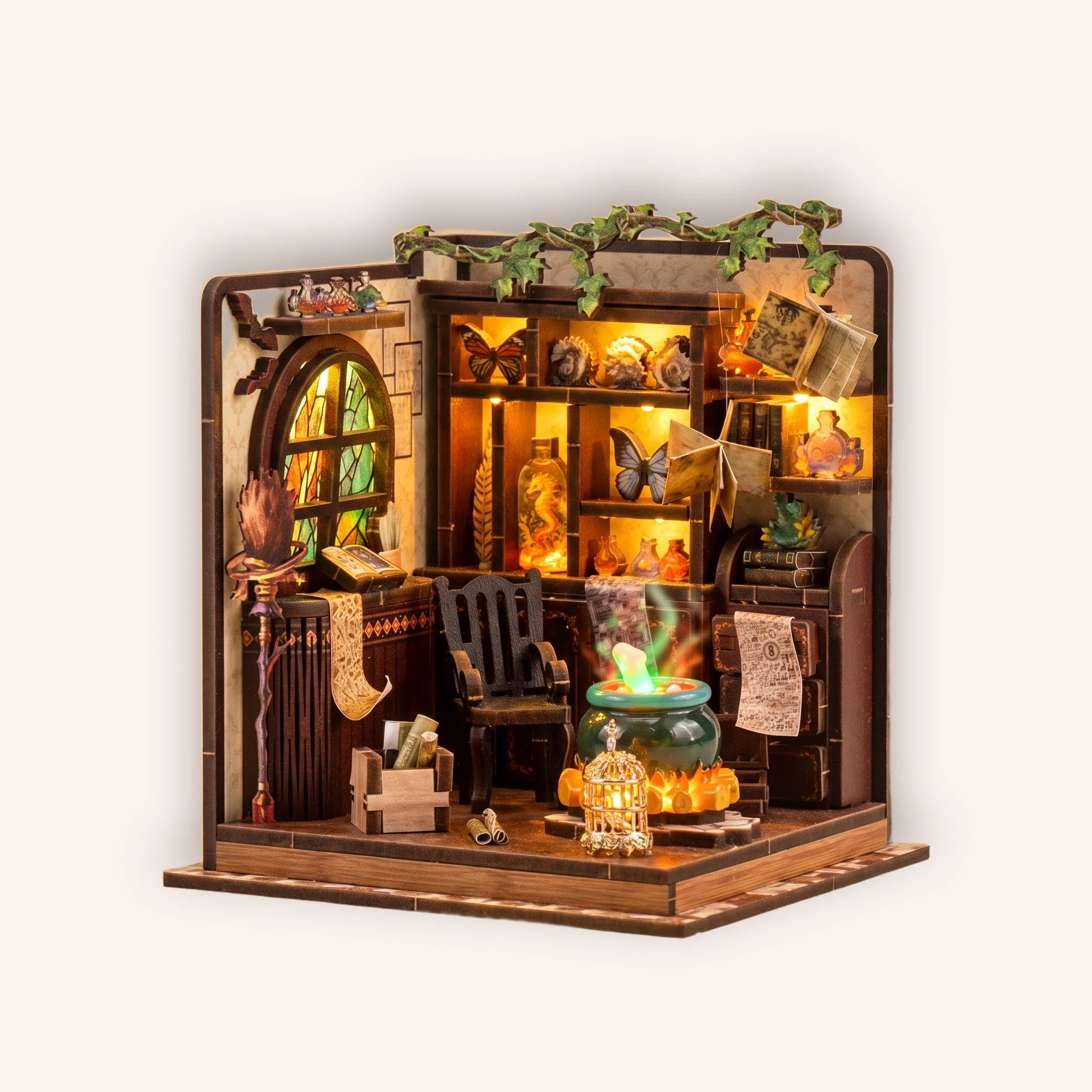 The Potion Workshop miniature roombox on a warm cream studio background, lit interior