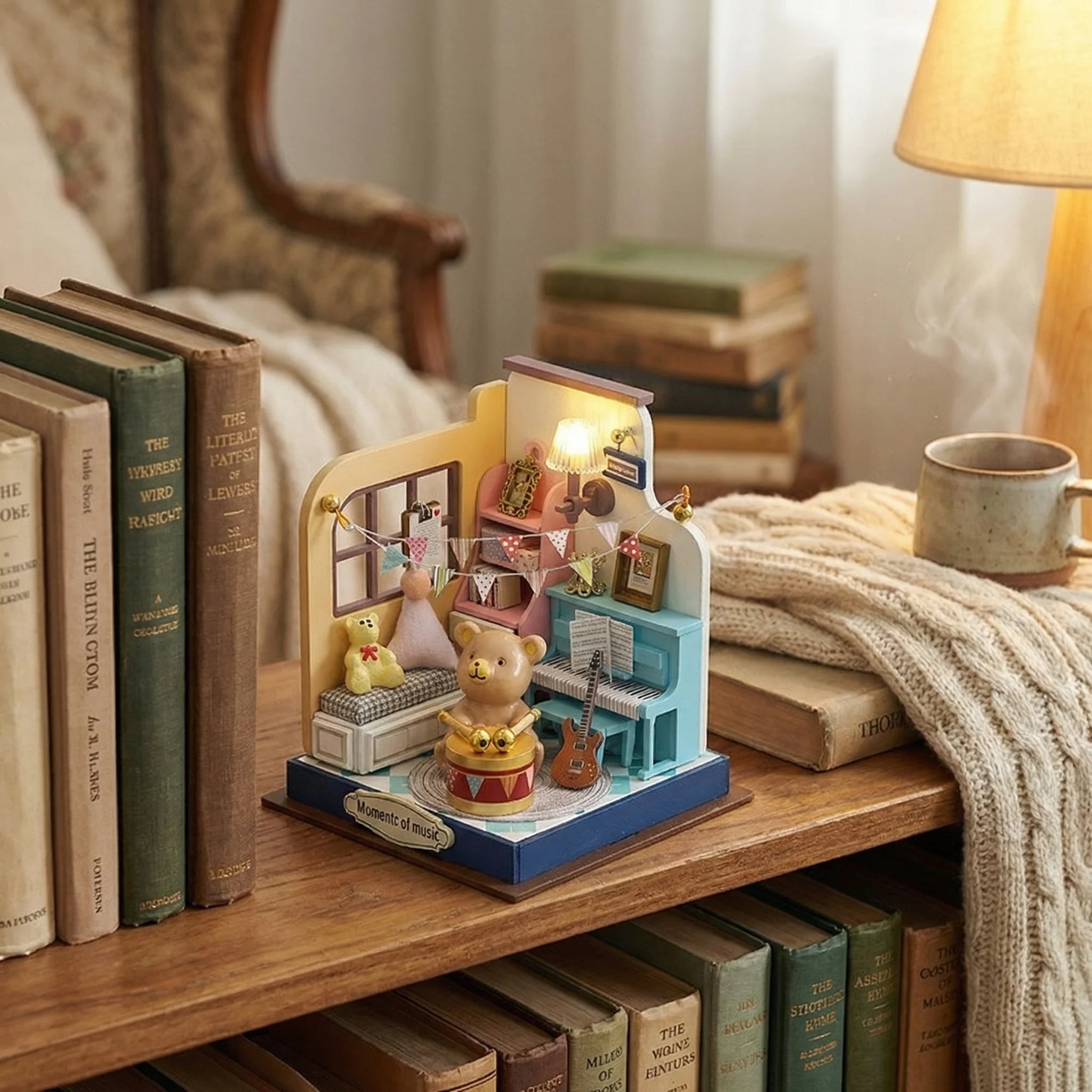 The Little Maestro miniature DIY kit displayed on wooden bookshelf with cozy blanket and vintage books in bedroom