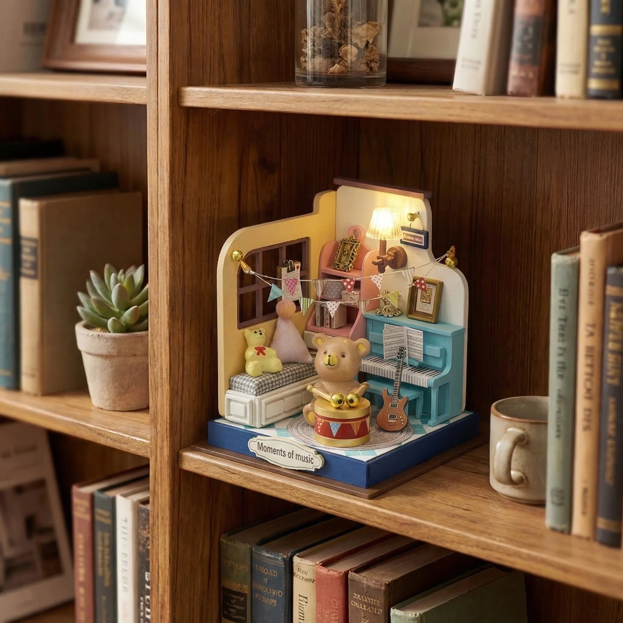 The Little Maestro miniature music room kit displayed on wooden bookshelf with bear piano and guitar DIY craft scene