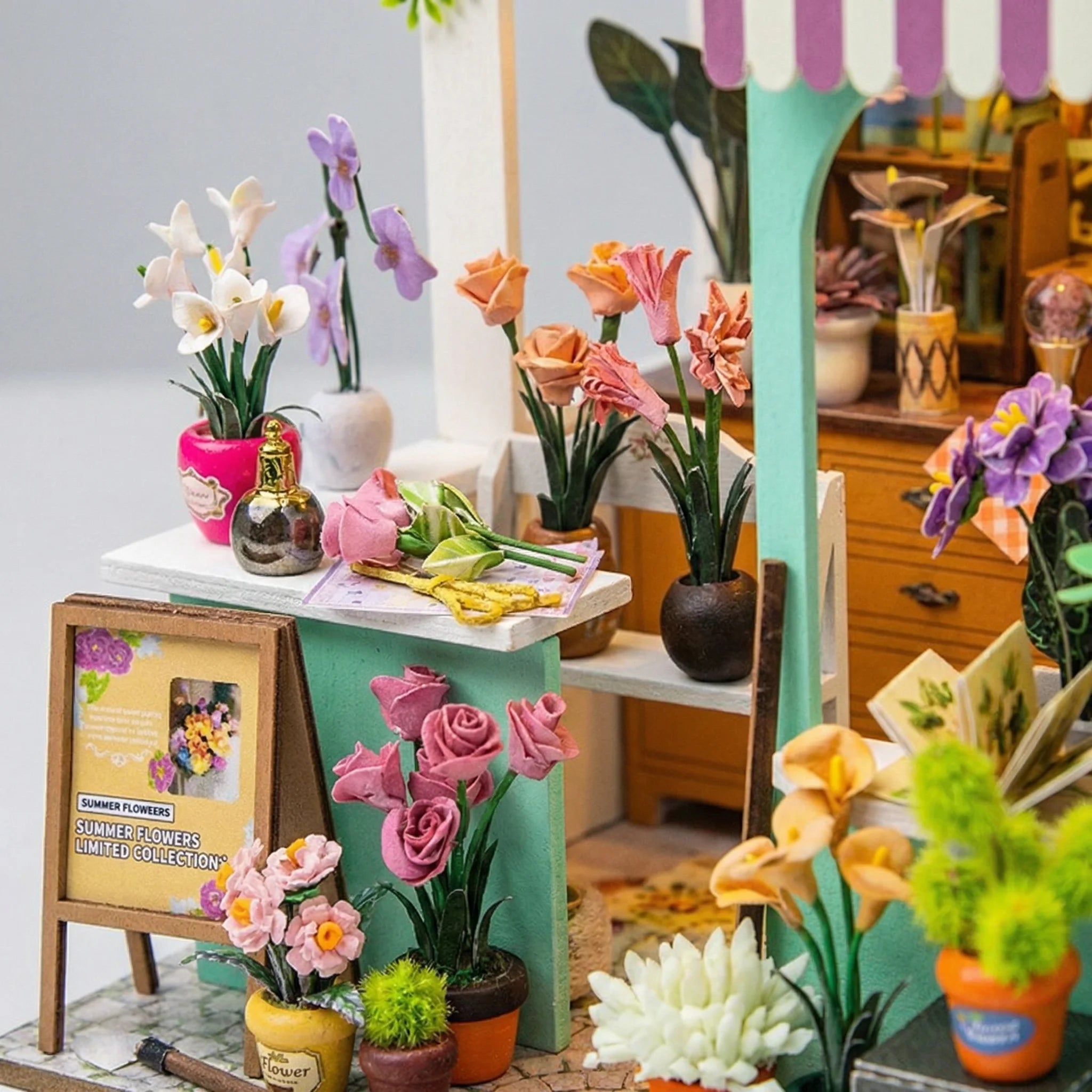 The Blossom Studio DIY miniature kit showing colorful handcrafted flowers in tiny vases on display shelves and furniture