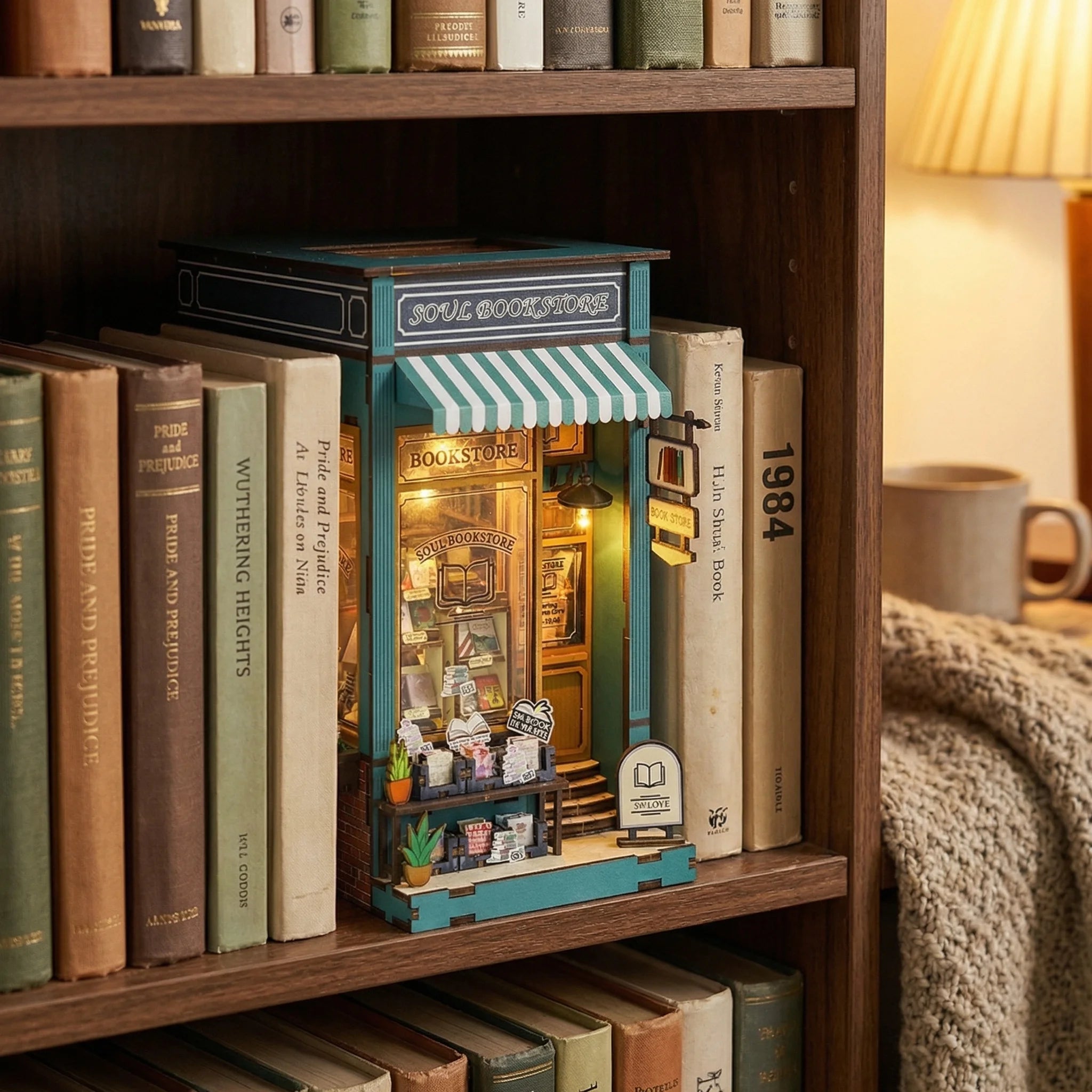 The Corner Bookstore miniature DIY kit displayed on wooden bookshelf between classic novels with warm lighting