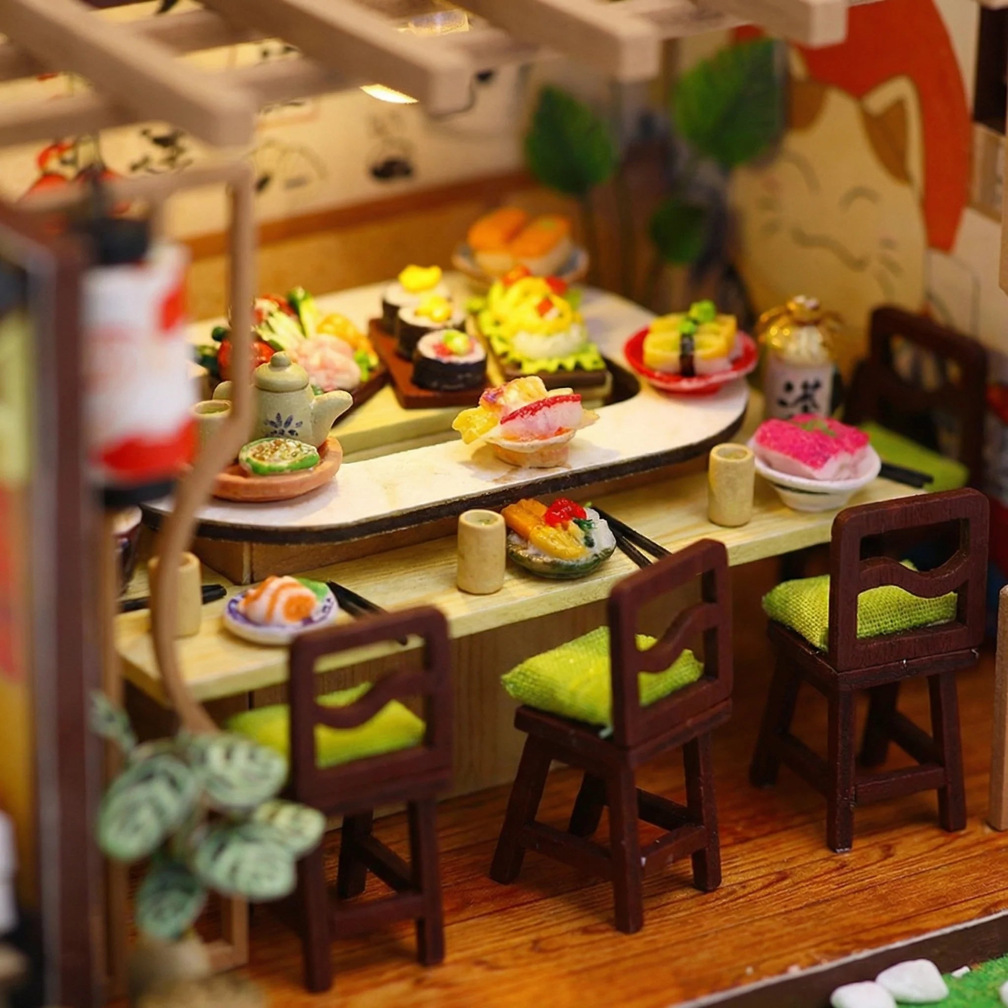 The Sakura Sushi Bar miniature kit assembled scene showing tiny sushi pieces on wooden table with chairs and tea set