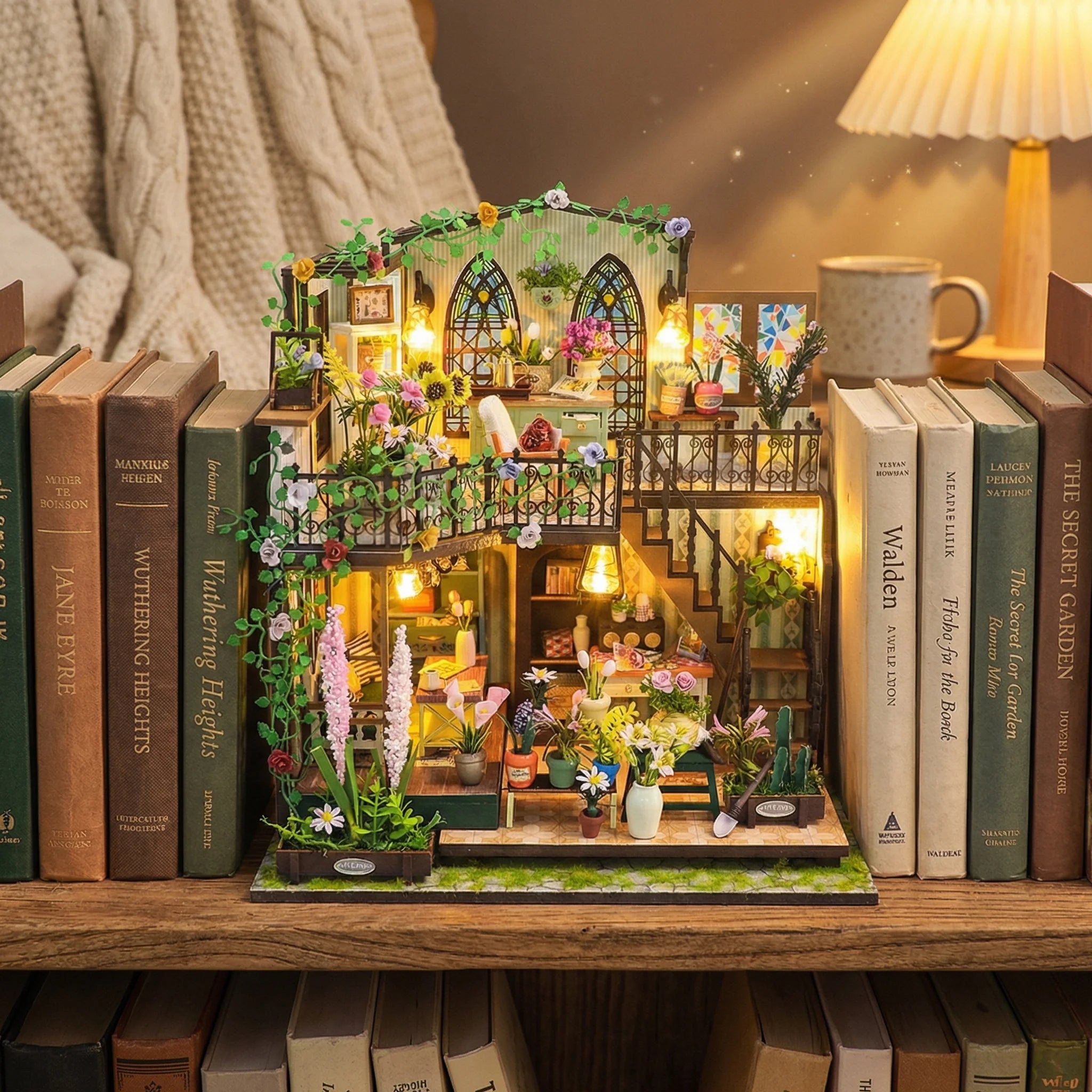 The Flower Loft miniature dollhouse kit displayed on bookshelf with warm lighting and floral details