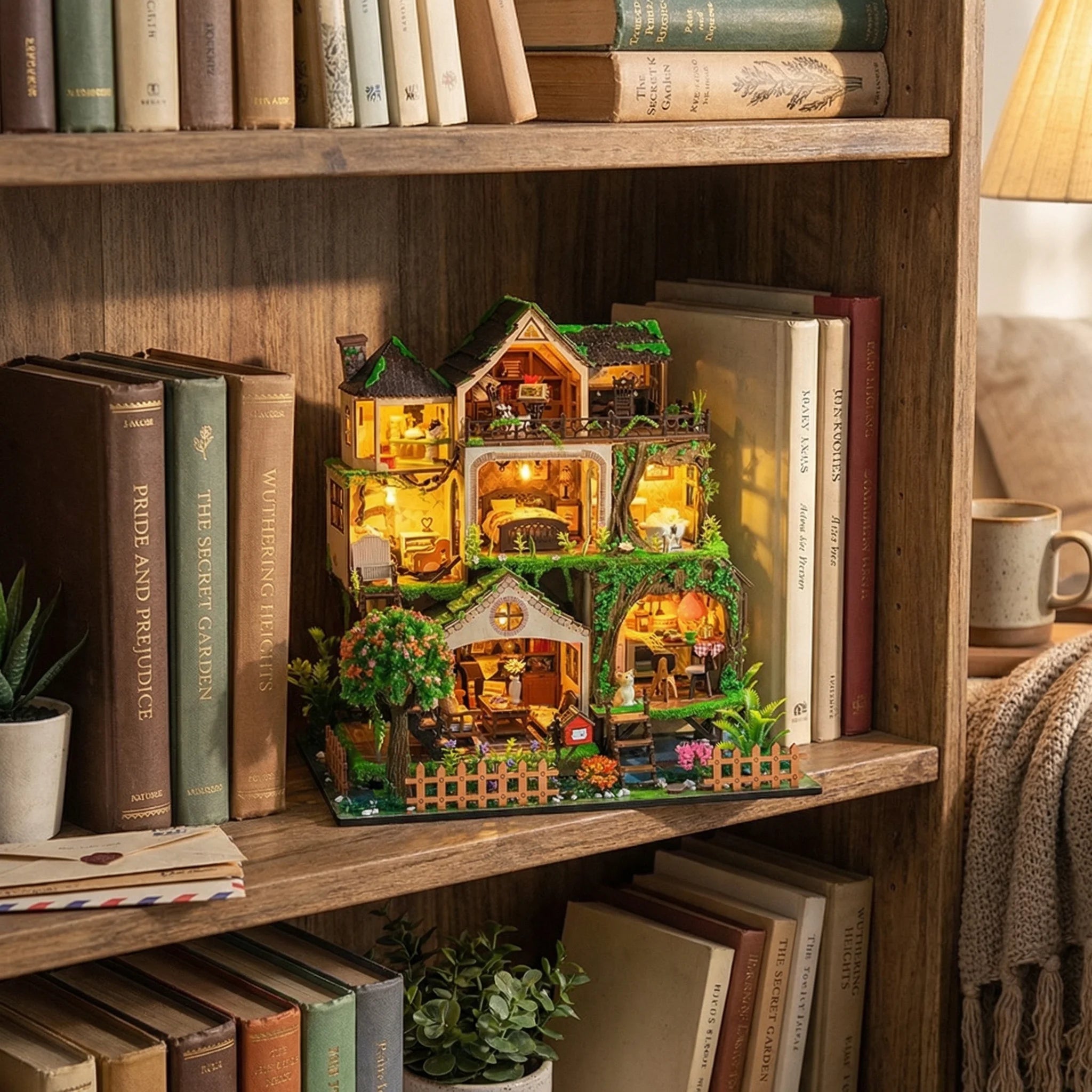 The Garden Hideaway miniature dollhouse kit displayed on wooden bookshelf with warm LED lights and detailed rooms