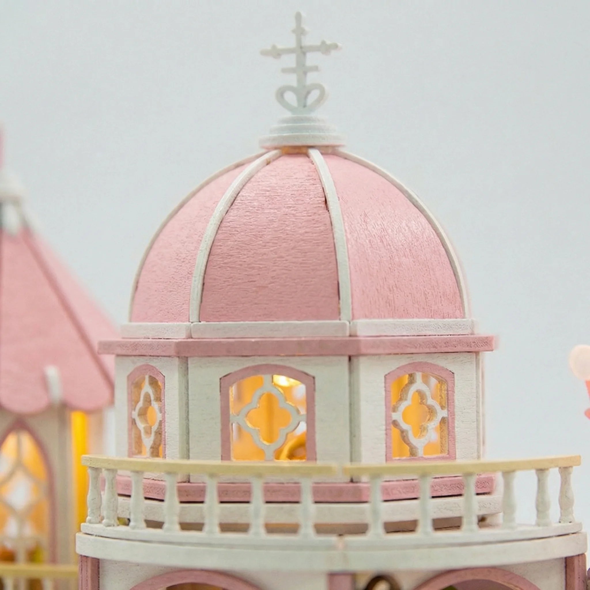 The Rose Palace miniature dollhouse kit featuring illuminated pink domed tower with ornate windows and white balcony railing