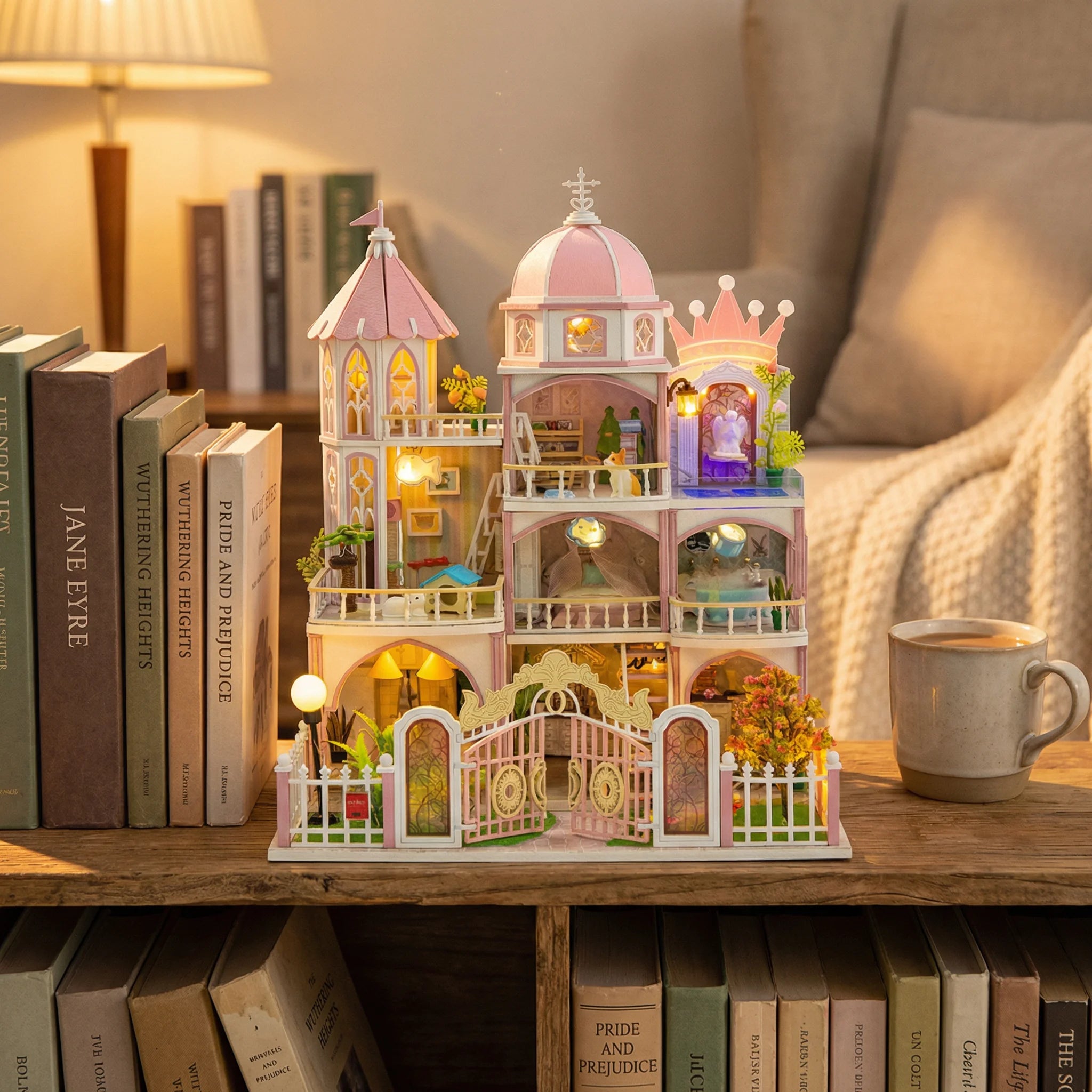 The Rose Palace miniature dollhouse kit displayed on wooden bookshelf with warm LED lights and coffee mug