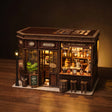 The Hidden Tavern miniature book nook hero, lit, on a dark warm backdrop