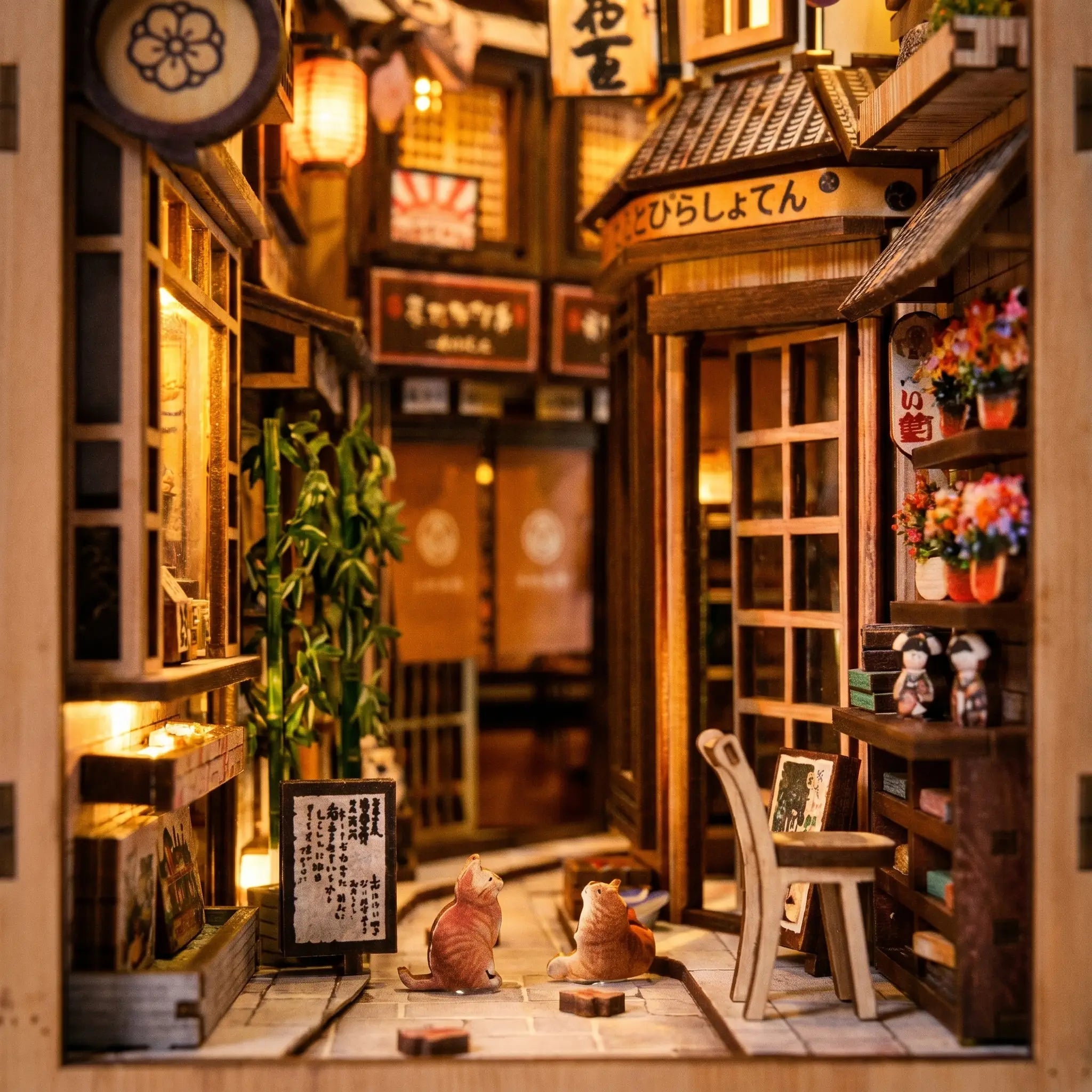 Close-up of the small cat beside a wooden stool and potted bamboo inside The Cat's Alley