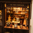 Close-up of the glowing bar counter lined with tiny bottles and glassware inside The Hidden Tavern