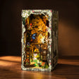 The Fairy Glen elf treehouse book nook glowing warm amber on a dark walnut surface