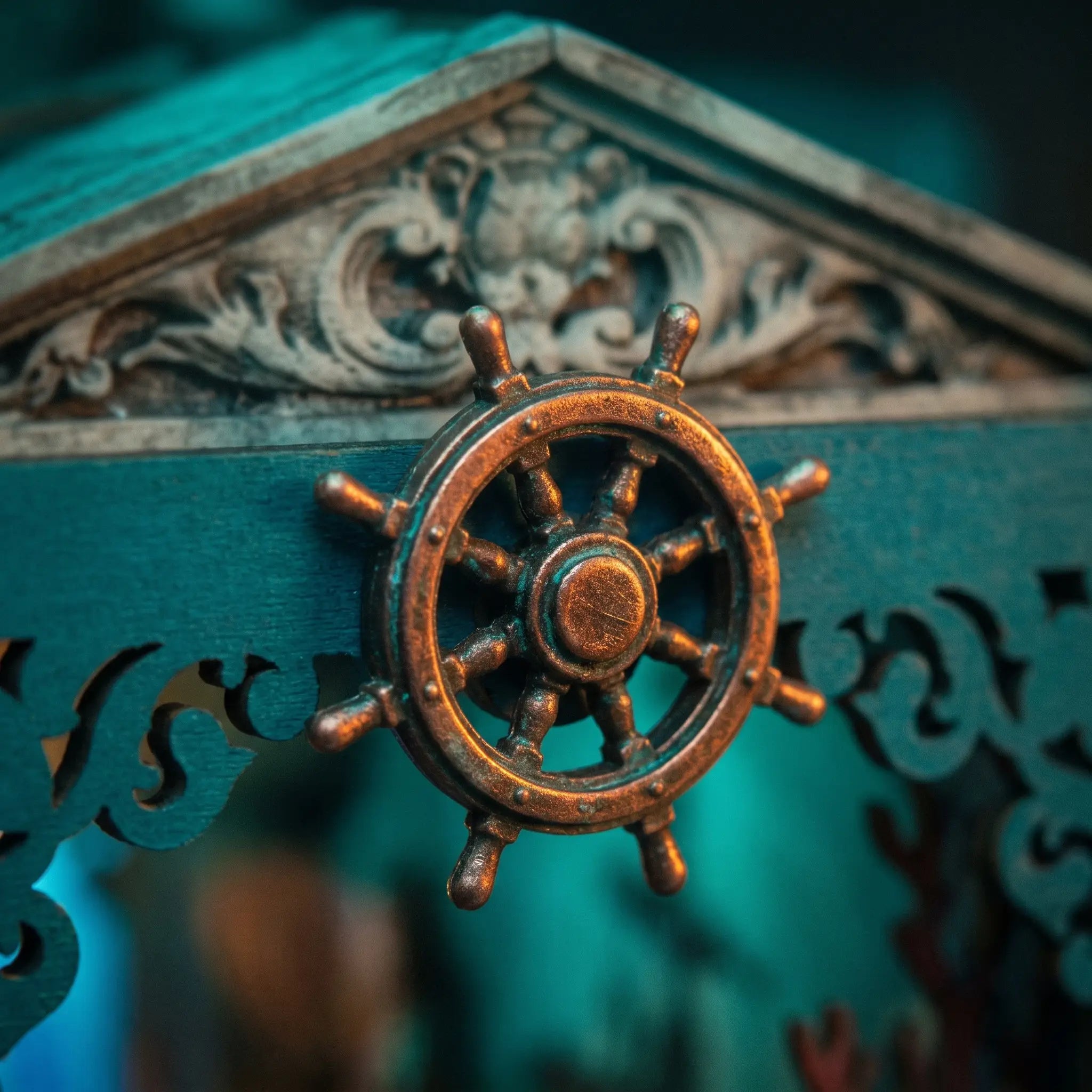 The Sunken World detail, copper ship's wheel on the carved frame