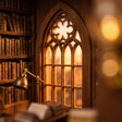 Macro detail of the arched gothic window glowing warm at dusk inside The Reading Room book nook