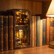 The Book Café book nook slotted on a shelf between books at dusk