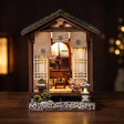 The Lantern House miniature Japanese house lit on a dark warm backdrop