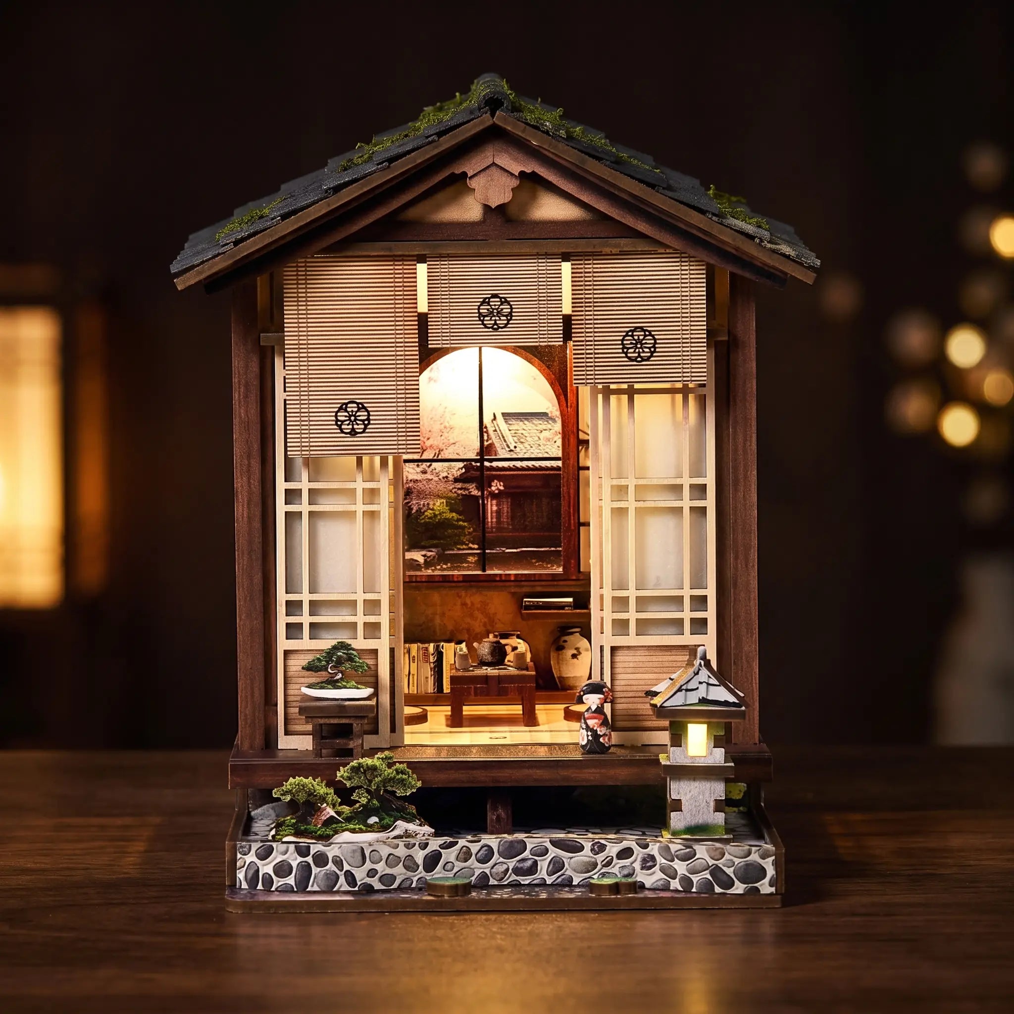 The Lantern House miniature Japanese house lit on a dark warm backdrop