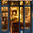 Macro view of the warm lit interior of The Corner Bookshop with tiny bookshelves