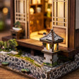 Close-up of the lit stone garden lantern beside The Lantern House