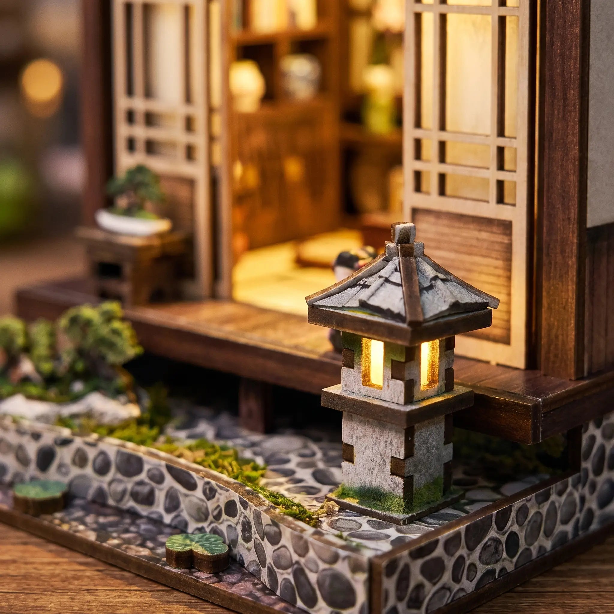 Close-up of the lit stone garden lantern beside The Lantern House
