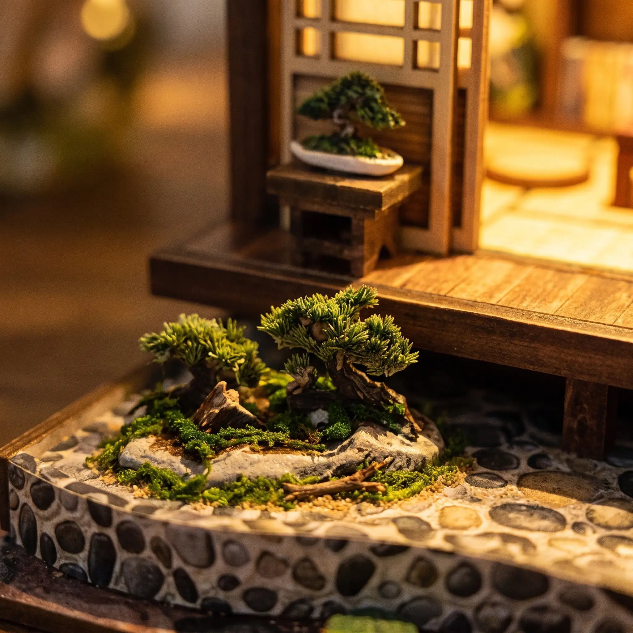 Close-up of the cobblestone garden base with bonsai at the foot of The Lantern House