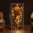 The Alchemy Academy DIY book nook kit, lit interior on a dark backdrop