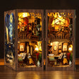 The Artist's Studio DIY book nook miniature on a dark walnut backdrop, interior glowing warm