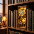 The Artist's Studio book nook slotted on a bookshelf between books at dusk