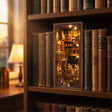 The Alchemy Academy book nook slotted on a shelf between books at dusk