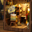 Macro close-up of the lit interior of The Artist's Studio with easel and starry mural