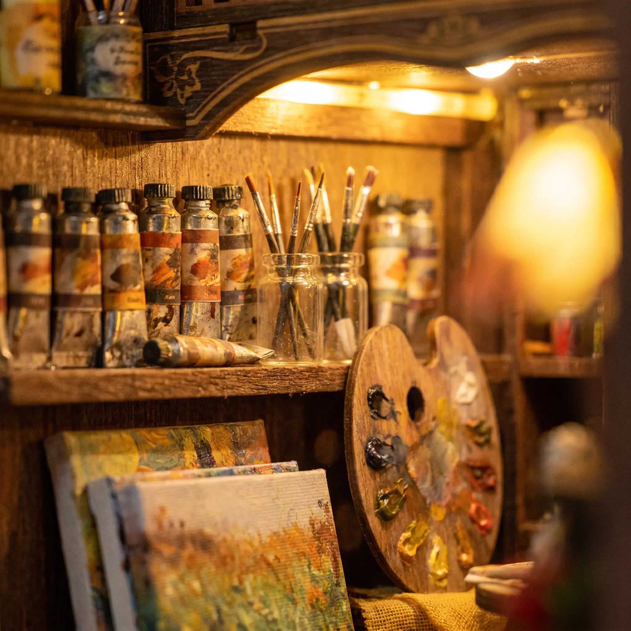 Close-up of the paint shelf with tubes, brushes and palette in The Artist's Studio