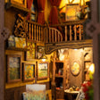 Close-up of the glowing lamp and framed paintings corner in The Artist's Studio
