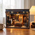 The Tailor's Atelier miniature tailor boutique on a warm wood desk, lifestyle