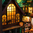 Close-up of the glowing arched window of The Haunted Manor with a black cat silhouette